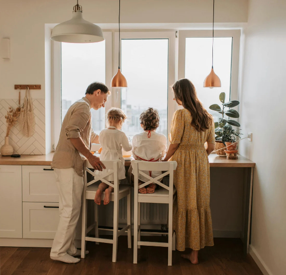 Famille dans une cuisine lumineuse équipée de fenêtres rénovées grâce à une solution de financement adaptée